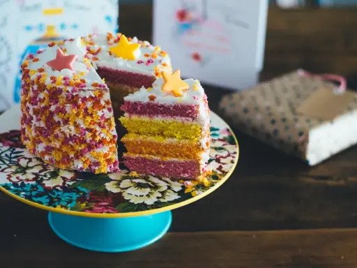 Pastel de capas arcoíris con estrellas de azúcar y chispas. ¡Ideas para decorar tartas que inspiran alegría y color!