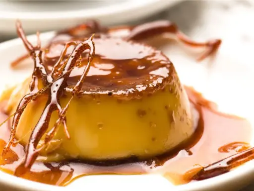 Delicioso flan de hielo con caramelo líquido y hebras crujientes de azúcar.