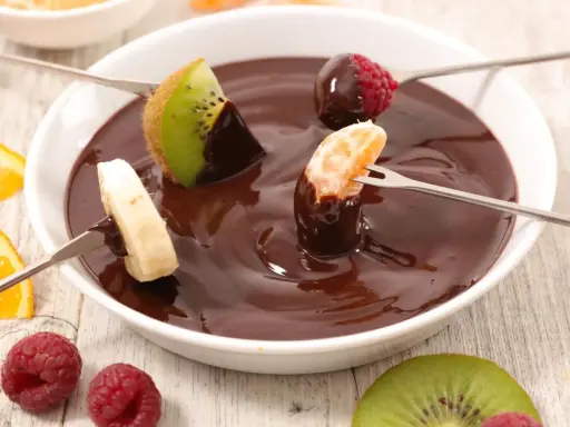 Deliciosa fondue de chocolate receta con frutas: kiwi, plátano, mandarina y frambuesas. ¡Un postre perfecto para compartir!