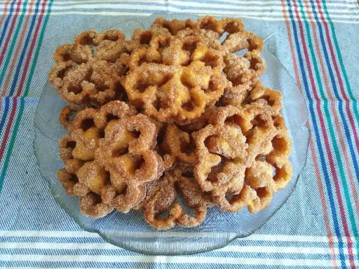 Un plato de flores de Semana Santa, crujientes y espolvoreadas con azúcar y canela, listas para disfrutar.