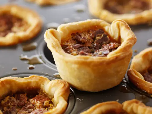 Mini tartas de nuez en molde, perfectas para recetas con masa quebrada.