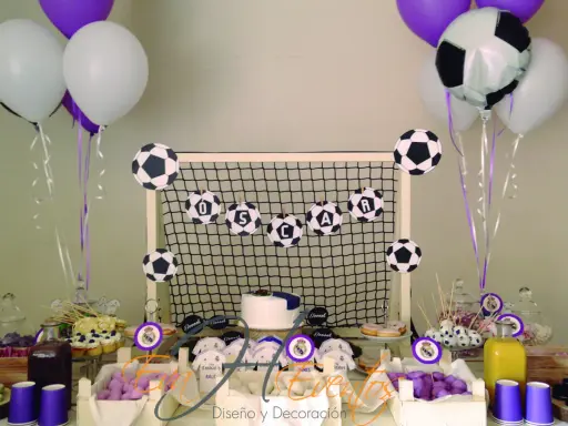Mesa de chuches del Real Madrid: balones de fútbol, globos, tarta y dulces para una fiesta temática.
