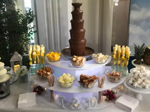 Ideas mesa dulce: fuente de chocolate blanco y negro, frutas, malvaviscos y galletas para una celebración.