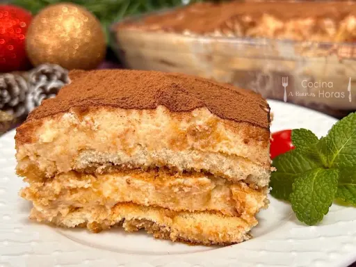 Delicioso tiramisú de turrón, con capas de bizcocho y crema, espolvoreado con cacao. ¡Un postre navideño irresistible!