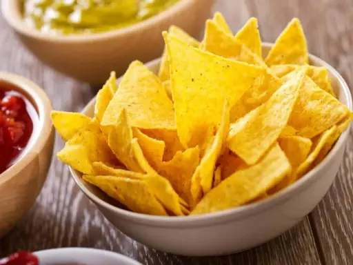 Un tazón lleno de crujientes nachos caseros, listos para ser sumergidos en salsa.