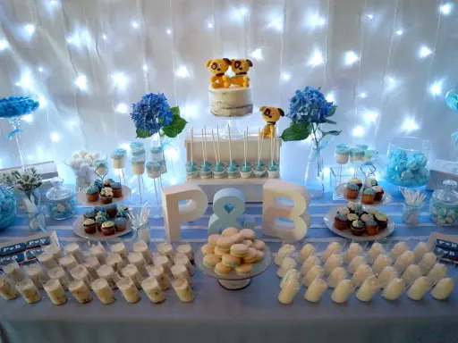 Mesa de dulces para una boda sencillo: pastel con perritos, cupcakes, macarons y postres individuales.
