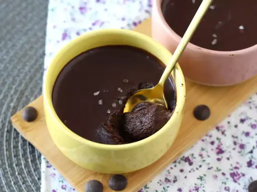 Delicioso mousse de chocolate en un cuenco amarillo, con una cuchara dorada lista para probarlo. ¡Un placer para los sentidos!