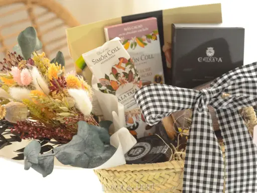 Cesta de regalo con chocolates, flores secas y un lazo de cuadros. Ideal para aprender como hacer una cesta de chuches para regalar.