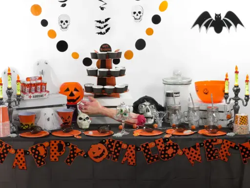 Mesa de **manualidades chuches Halloween** con calabazas, fantasmas, calaveras y dulces.