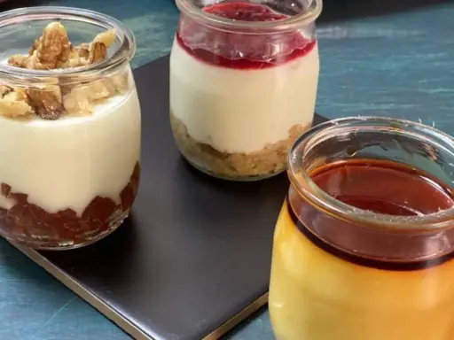 Tres postres individuales en frascos: uno con nueces y mermelada, otro con galleta y frutos rojos, y un flan de queso sin horno con caramelo.