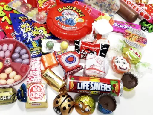 Un surtido de chuches años 60, con caramelos, chicles y chocolates, evocando la nostalgia de la infancia.