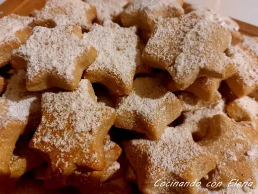 Deliciosas galletas caseras de pueblo con forma de estrella, espolvoreadas con azúcar glas. Perfectas para acompañar un café.