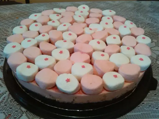 Tarta de nubes de golosina, cubierta con malvaviscos rosas y blancos, cada uno con una pequeña estrella roja.