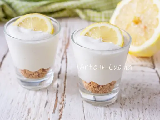 Dos vasitos de mousse de limón con base de galleta y rodaja de limón encima.