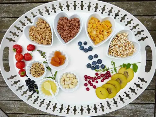 Bandeja con variedad de cereales, frutas y frutos secos, perfecta para una merienda cumpleaños infantil.