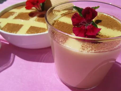 Deliciosas natillas Thermomix, espolvoreadas con canela y decoradas con flores rojas. ¡Un postre casero perfecto!