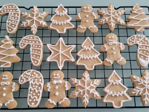 Galletas de jengibre decoradas con glaseado blanco: hombres, árboles, bastones de caramelo y copos de nieve.