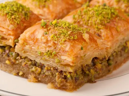 Delicioso baklava casero, capas crujientes de masa filo rellenas de nueces y bañadas en almíbar. ¡Una receta irresistible!