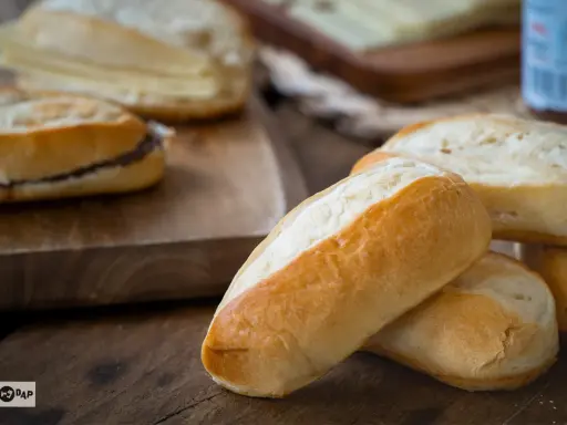Pan de leche recién horneado, perfecto para tu próxima receta. Uno tiene relleno de chocolate.
