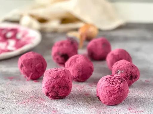 Deliciosas trufas de chocolate cubiertas de polvo rosa vibrante. Un bocado dulce y tentador.