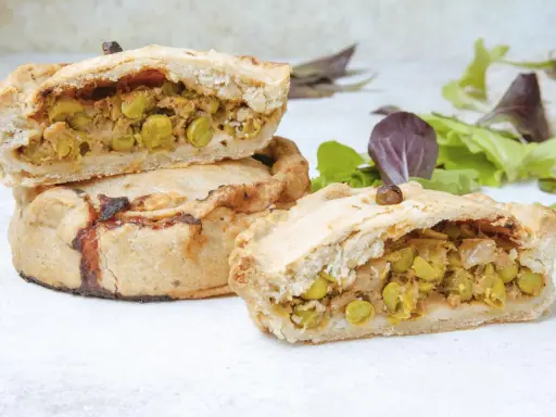 Empanadas mallorquinas rellenas de guisantes y carne, con una masa dorada y crujiente.
