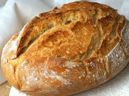 Pan casero recién horneado, con corteza dorada y crujiente. Perfecto para tu próxima receta de pan casero.