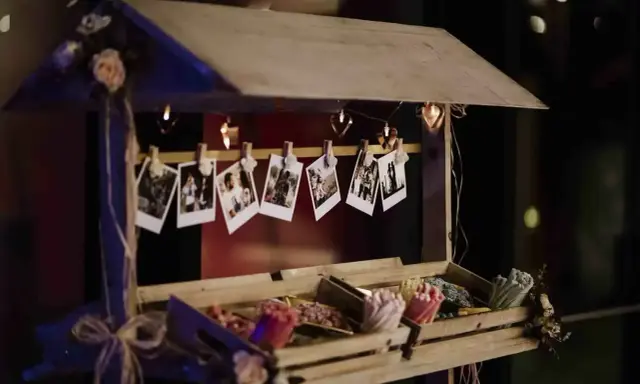 Un carrito de chuches casero decorado con fotos y luces en forma de corazón.