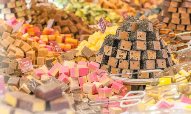 Montón de caramelos de antes, de diferentes sabores y colores, apilados en un puesto.