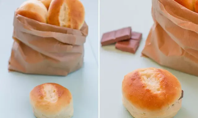 Pan de leche recién horneado en una bolsa de papel, con uno abierto mostrando chocolate.