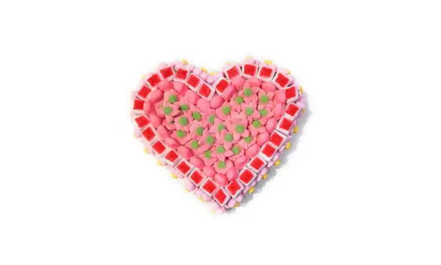 Corazón de tartas de chuches de San Valentín, decorado con flores rosas y detalles verdes.