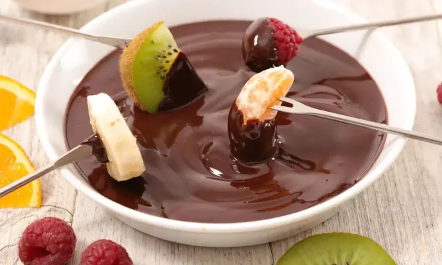 Deliciosa fondue de chocolate receta con frutas: kiwi, plátano, mandarina y frambuesas. ¡Un postre perfecto para compartir!