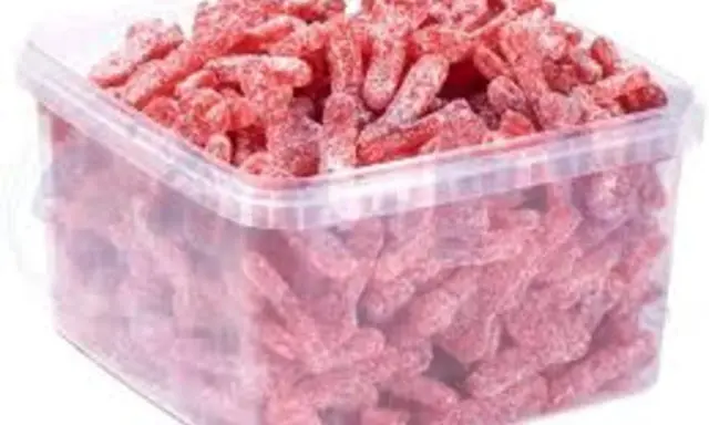 Un cubo transparente lleno de gominolas rojas con forma de gusano, cubiertas de azúcar. ¡Parecen la chuche más ácida del mundo!