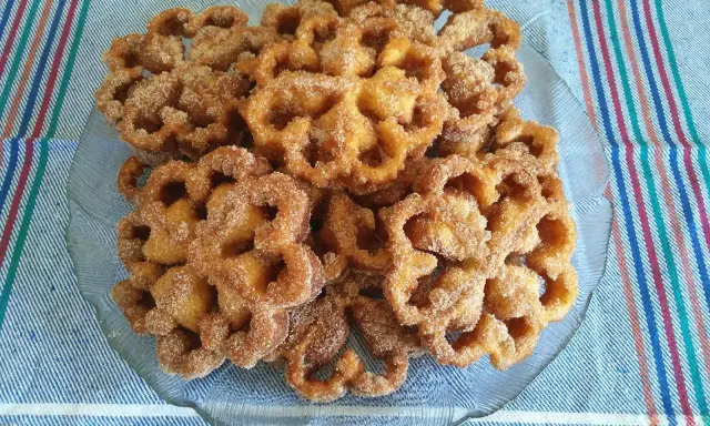 Un plato de flores de Semana Santa, crujientes y espolvoreadas con azúcar y canela, listas para disfrutar.