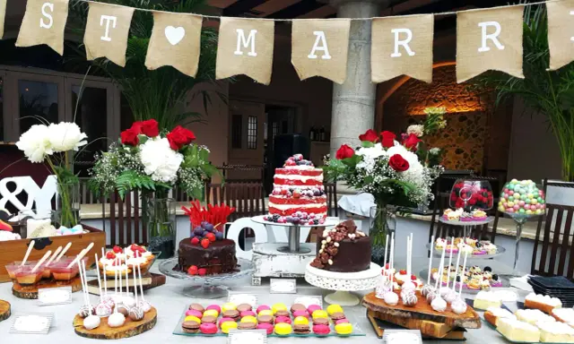 Una mesa de dulces sencillas para una celebración, con pasteles, macarons y cake pops.