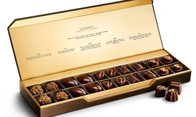 Caja abierta de chocolates finos, "la chuche más cara del mundo", con descripciones de sabores inspirados en elementos naturales.