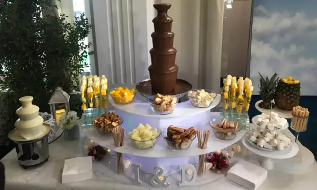 Ideas mesa dulce: fuente de chocolate blanco y negro, frutas, malvaviscos y galletas para una celebración.