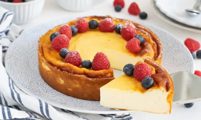 Tarta cremosa decorada con frambuesas y arándanos, como un petit yogur de lujo.