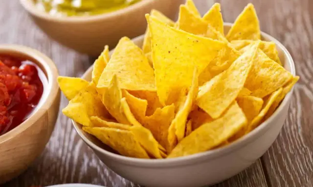 Un tazón lleno de crujientes nachos caseros, listos para ser sumergidos en salsa.