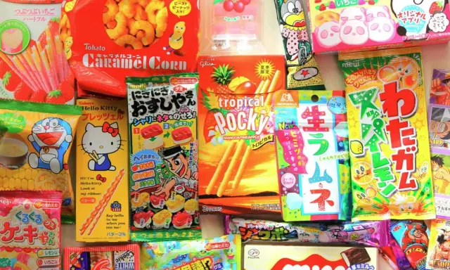 Un surtido vibrante de chuches famosas japonesas, incluyendo Pocky, Caramel Corn y dulces de Hello Kitty y Doraemon.