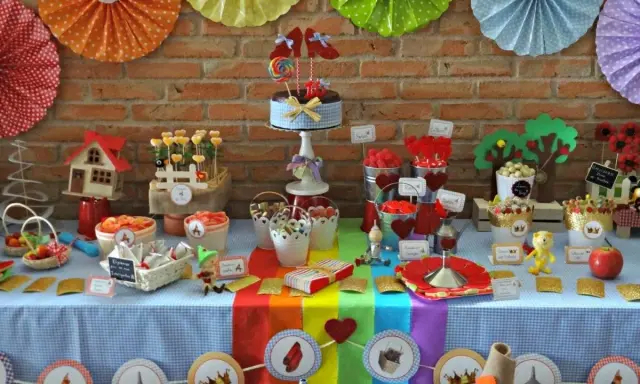 Una mesa dulce casera llena de color y fantasía, con dulces, pasteles y decoraciones temáticas.