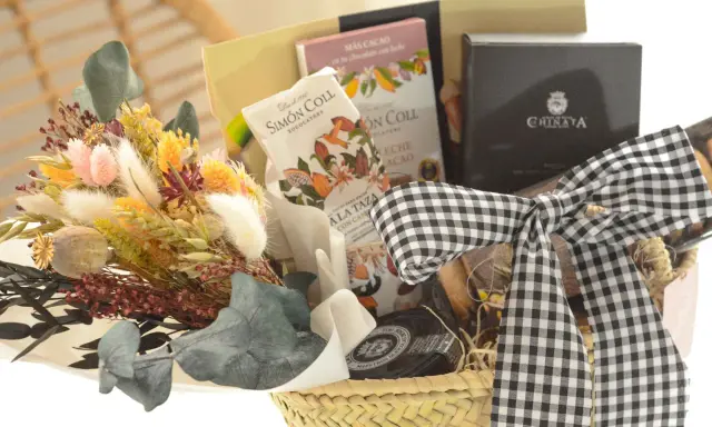 Cesta de regalo con chocolates, flores secas y un lazo de cuadros. Ideal para aprender como hacer una cesta de chuches para regalar.