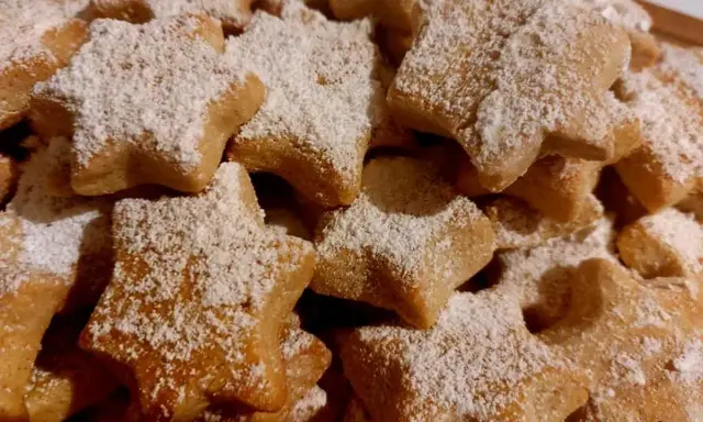Deliciosas galletas caseras de pueblo con forma de estrella, espolvoreadas con azúcar glas. Perfectas para acompañar un café.