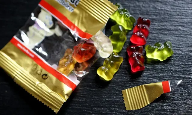 Osos de goma Haribo de colores esparcidos sobre una superficie oscura. ¡Cuidado, las chuches caducan!