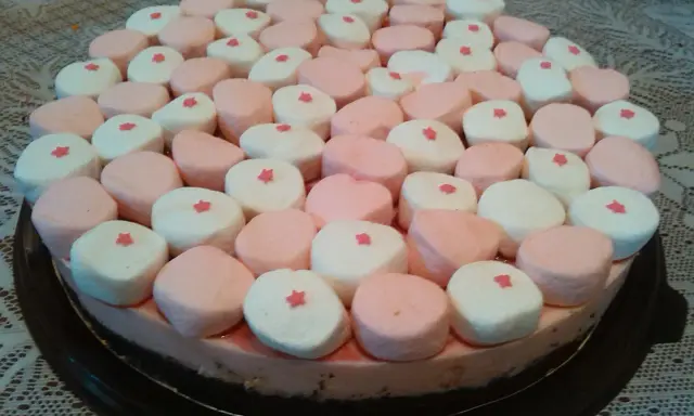 Tarta de nubes de golosina, cubierta con malvaviscos rosas y blancos, cada uno con una pequeña estrella roja.