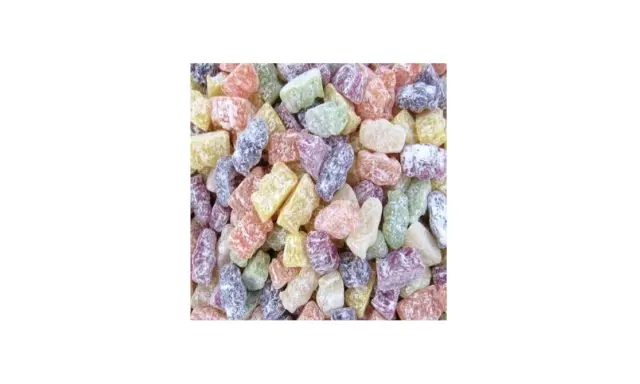 Montón de caramelos de goma de colores, como jelly babies, esparcidos.