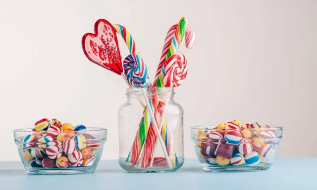 Dulces coloridos y piruletas en forma de corazón y espiral, perfectos para manualidades como regalar chuches.