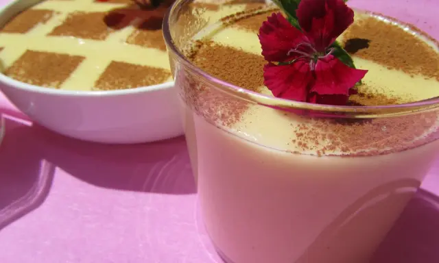 Deliciosas natillas Thermomix, espolvoreadas con canela y decoradas con flores rojas. ¡Un postre casero perfecto!