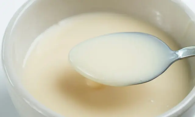 Cuchara con leche evaporada, un ingrediente cremoso y versátil.