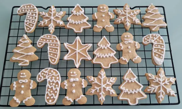 Galletas de jengibre decoradas con glaseado blanco: hombres, árboles, bastones de caramelo y copos de nieve.