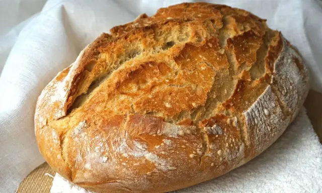 Pan casero recién horneado, con corteza dorada y crujiente. Perfecto para tu próxima receta de pan casero.